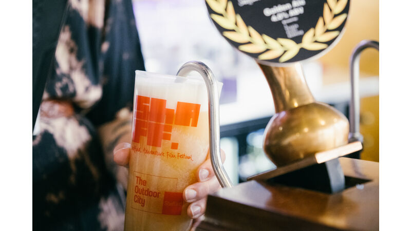 Close up of a ShAFF branded ale being poured into a ShAFF branded pint glass