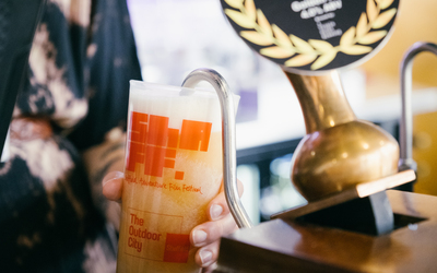 Close up of a ShAFF branded ale being poured into a ShAFF branded pint glass