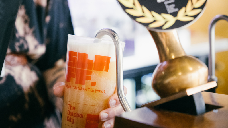 Close up of a ShAFF branded ale being poured into a ShAFF branded pint glass