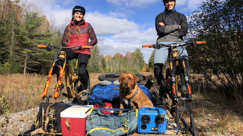 Riding The Rails Poster image showig two cyclists and a dog on a home made contraption cycling along a disused railyway line