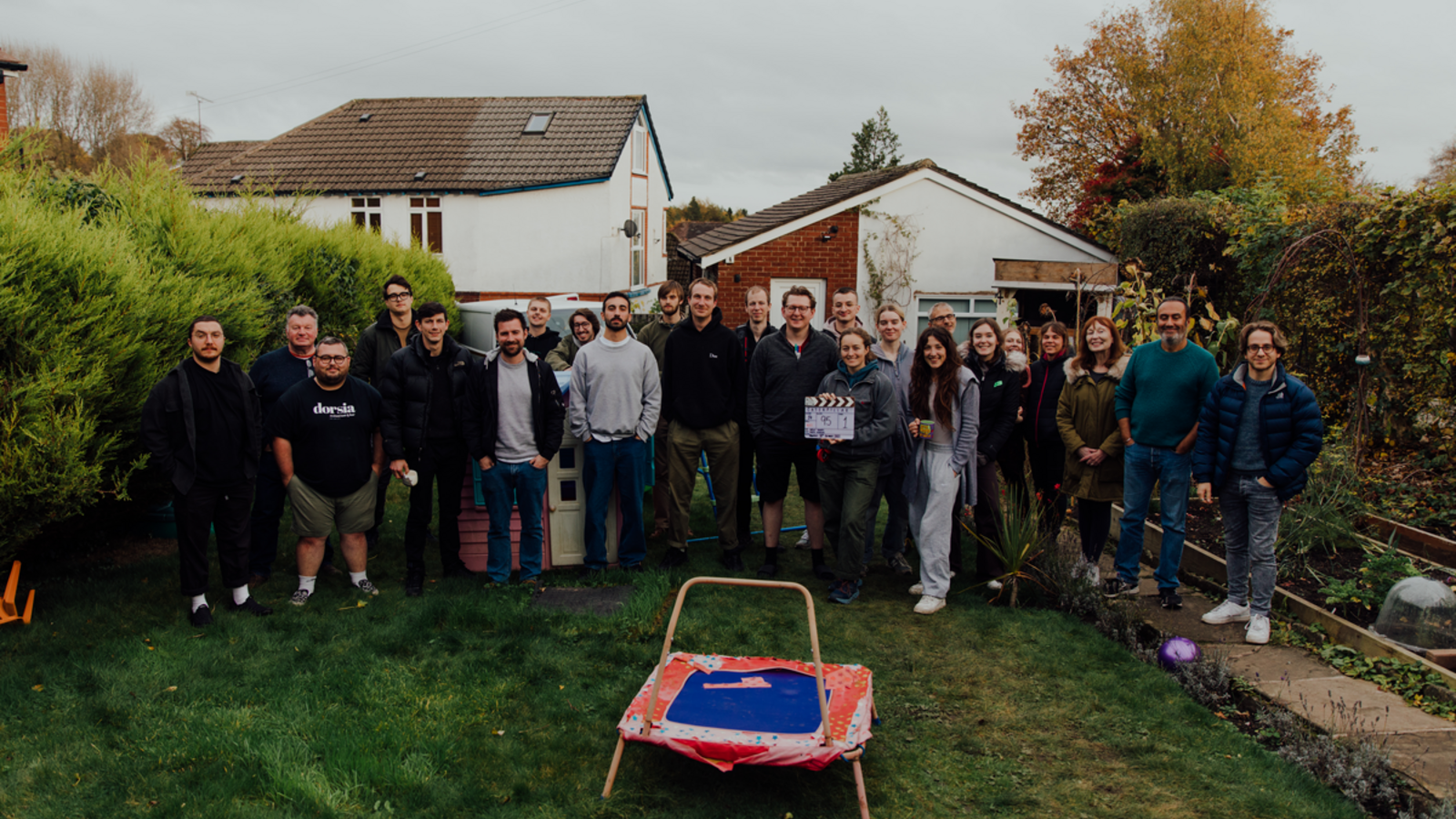 The crew working on the short film standing for a group photo in a back garden