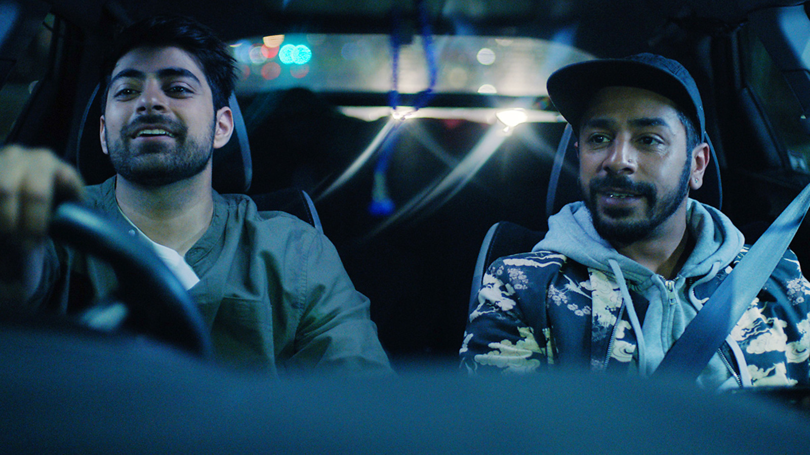 Abz and Sid ride in the car in a scene from TASBEEH