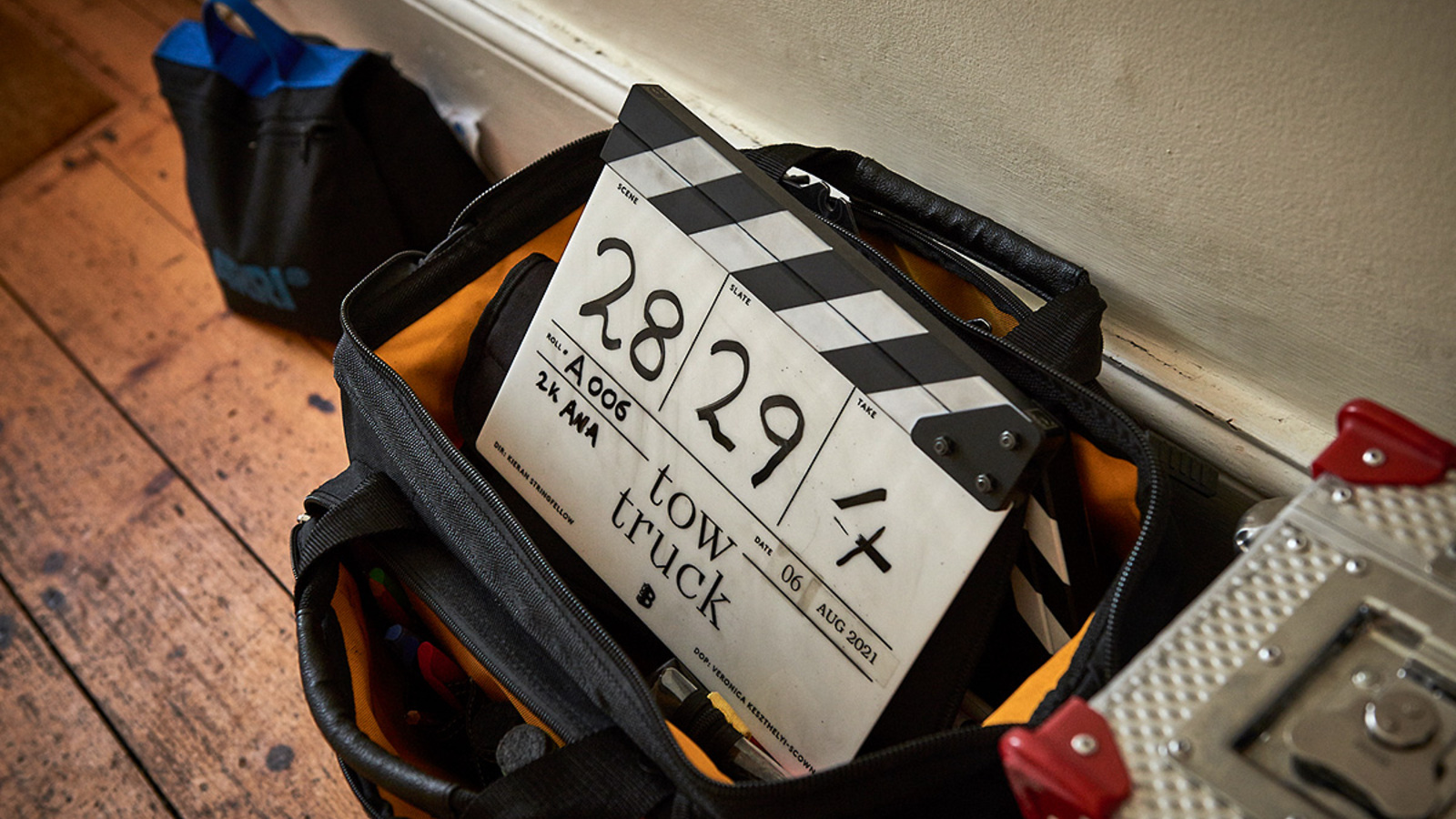 Behind the scenes on TOW TRUCK, a clapperboard sticking out of an equipment bag