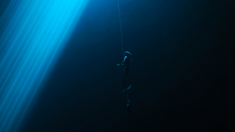 Helena Bourdillon freediving next to a light beam