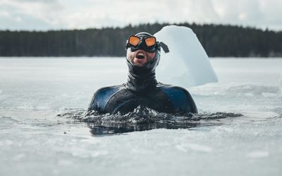 Freediving athlete Arthure G.B. prepares to dive under the ice.