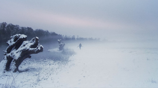 Man standing in foggy snowy landscape 