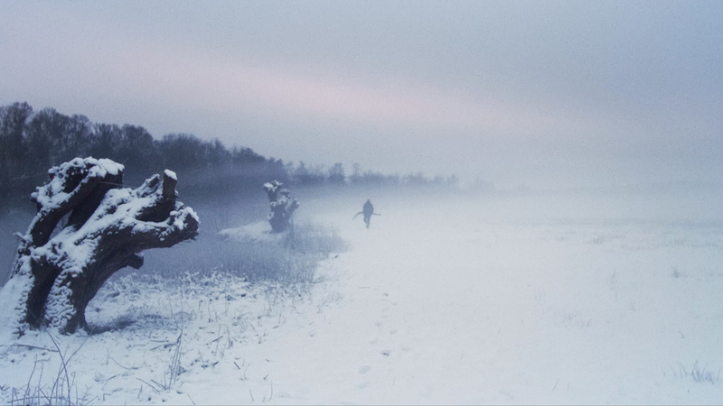 Man standing in foggy snowy landscape 