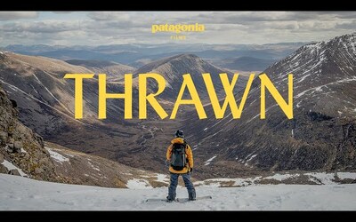 A snowboarder in a yellow jacket looks out onto a mountainous view. The text onscreen reads "Patagonia Presents Thrawn"