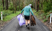 Beau Miles collects rubbish from the roadside.