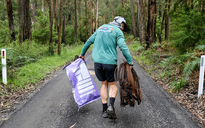 Beau Miles collects rubbish from the roadside.