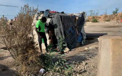 Ayman, a young refugee from Sudan, outside his shelter.