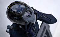 Athlete puts on her helmet just before she drops in on her sled.