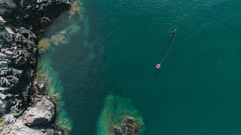 Aerial view of spearfisherman in ocean preparing to dive