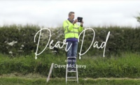 Man in high vis jacket standing on step ladder filming with an iPad