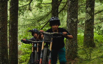 Film posters showing two mountain bikers pushing their bikes uphill