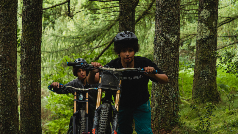 Film posters showing two mountain bikers pushing their bikes uphill