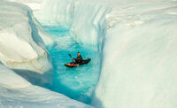 A man descending from a waterfall in the ice