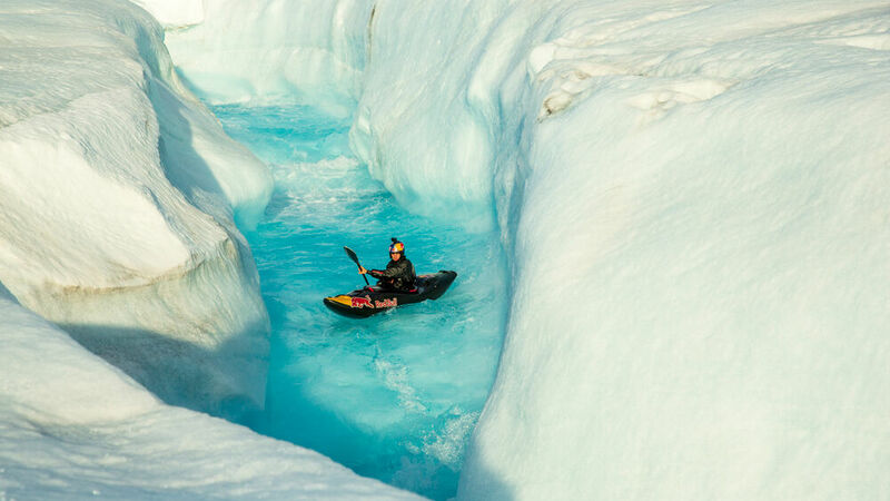 A man descending from a waterfall in the ice