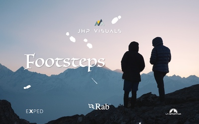 An image depicting the silhouette of 2 people standing on a ridge line with snowy mountains in the background. The text says JHP Visuals- Footsteps  
