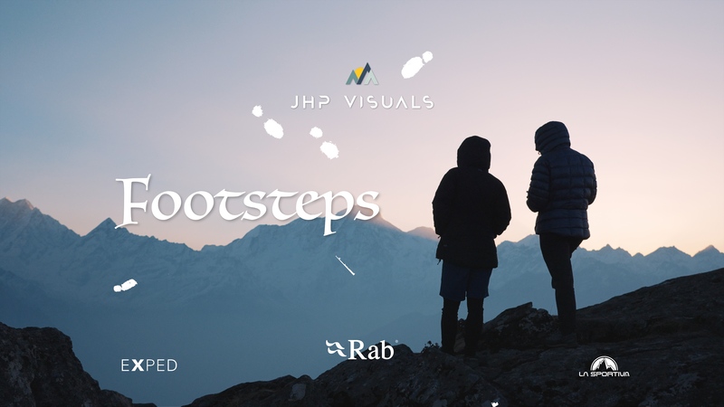 An image depicting the silhouette of 2 people standing on a ridge line with snowy mountains in the background. The text says JHP Visuals- Footsteps  