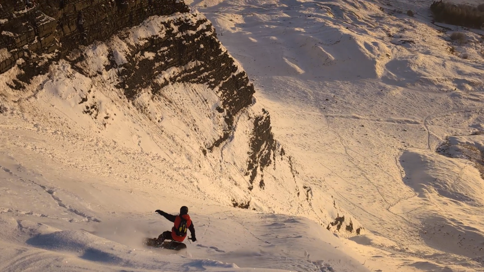 A snowboarder on the upper section of Mam Tor gully at sunrise. Photo by Si Bainbridge