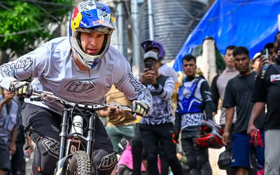 Captured by Frizzon in a remote town in North East India, this image shows mountain biker Pedro Burns in full focus as he rides downhill during an urban race, while a crowd of spectators and fellow riders watch and film the moment on their phones, embodying the raw energy and community spirit of the event.