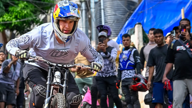 Captured by Frizzon in a remote town in North East India, this image shows mountain biker Pedro Burns in full focus as he rides downhill during an urban race, while a crowd of spectators and fellow riders watch and film the moment on their phones, embodying the raw energy and community spirit of the event.