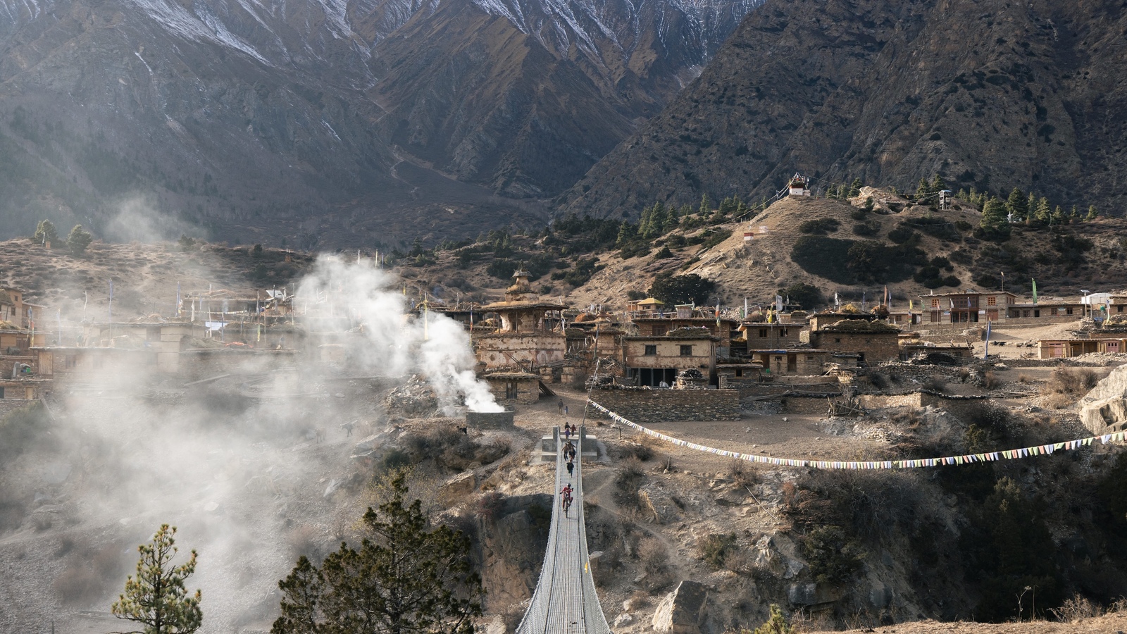 Kilian Bron and local childs on a suspension bridge in the remote Ringmo village, Dolpo, Nepal. 