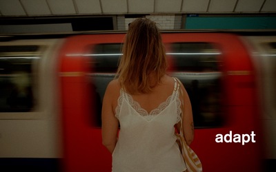 Charlotte stands in front of a rushing train. 