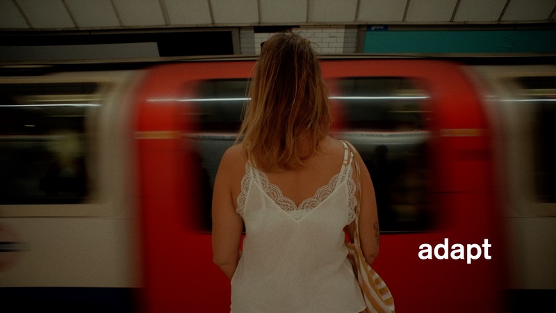 Charlotte stands in front of a rushing train. 