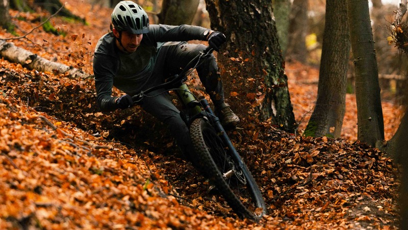 Mountain Biker Kyle Beattie making a sharp turn in a deep leaf section of the trail.