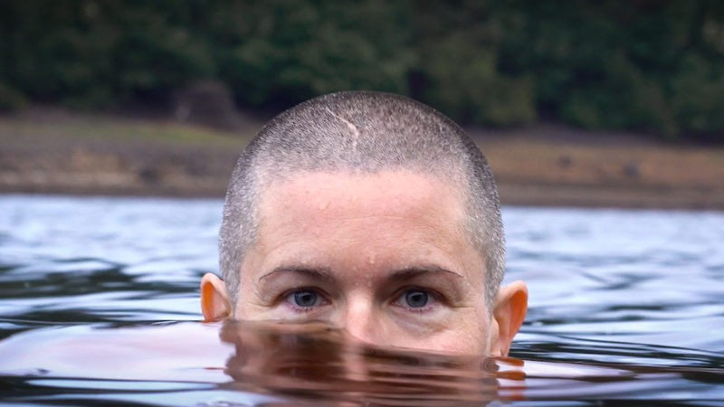 Portrait of autistic wild swimmer, Bea submerged to her nose in water