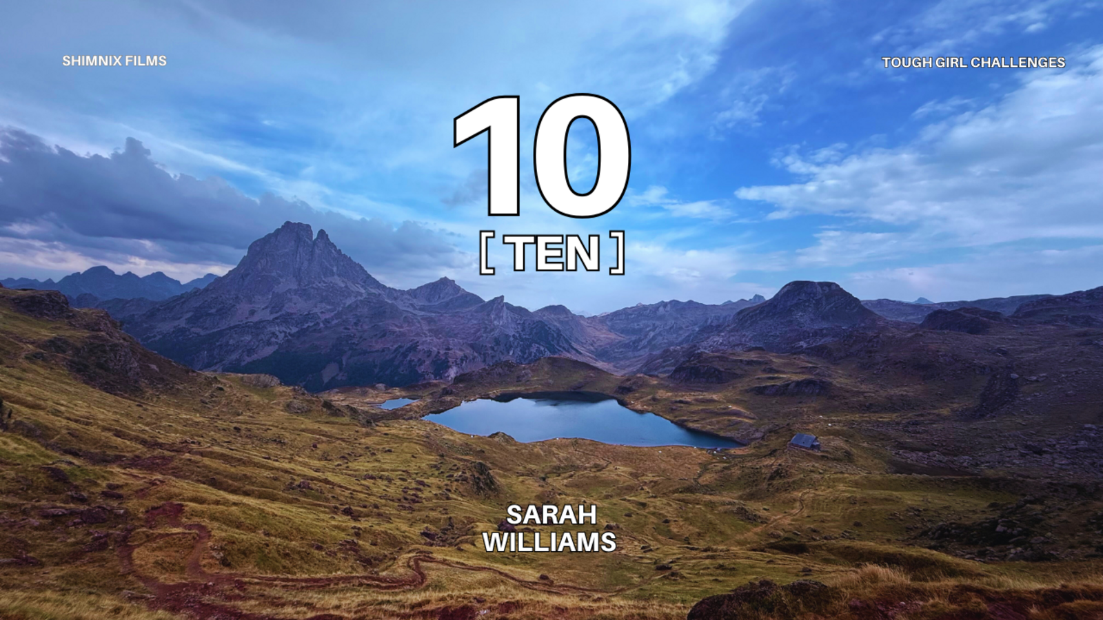 A picture of the mountains in France, with a lake in the middle. Large number 10 in the centre - with T E N underneath. 