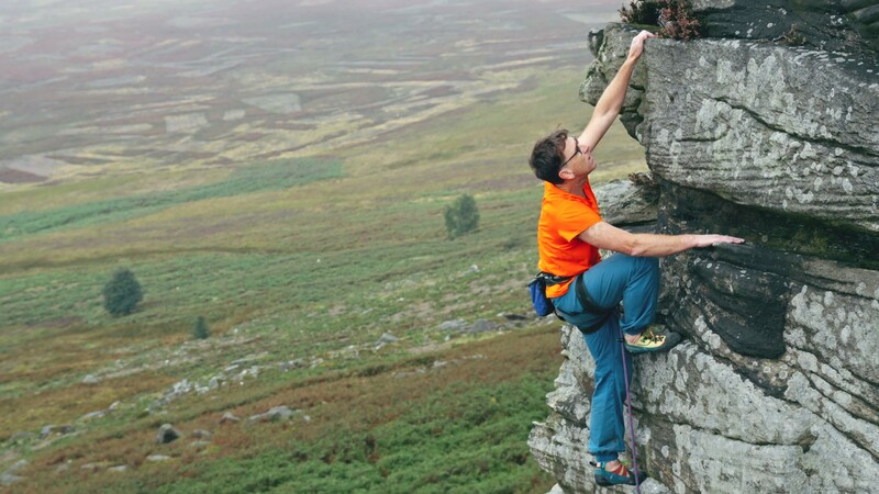 Climber at the top of a crag at stanage