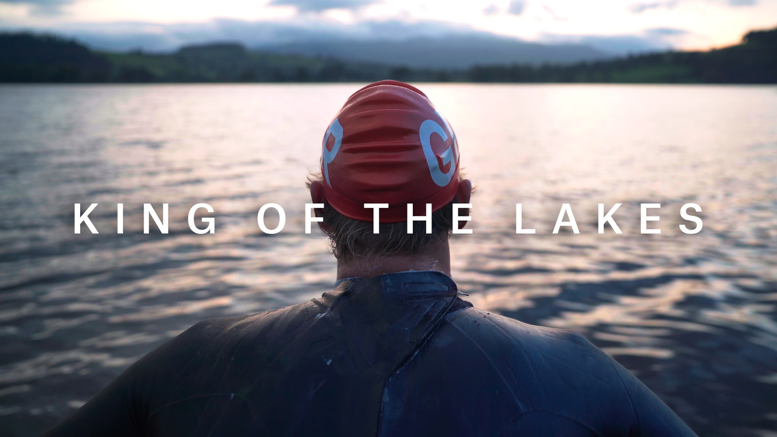 Hector Pardoe, an Olympic open water swimmer, sits, looking out over the final lake as the sun sets. Title reads, "King of the Lakes"