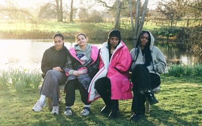 All four Swim Sistas sit on a bench