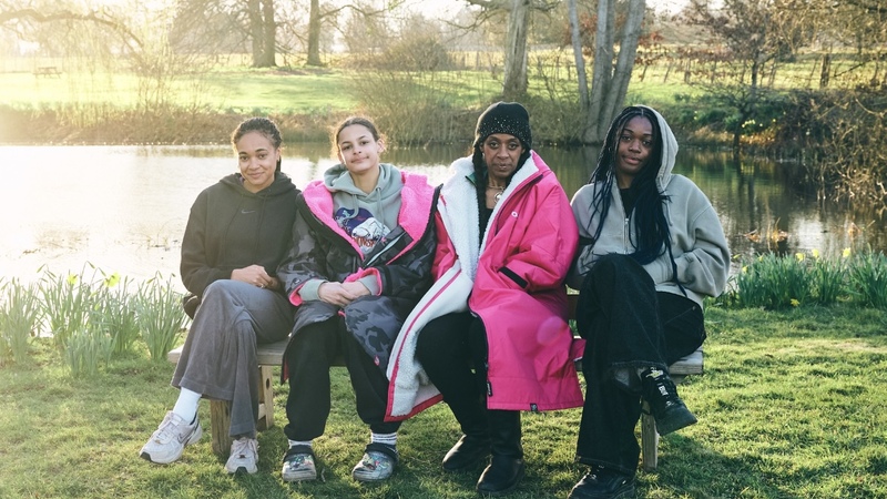 All four Swim Sistas sit on a bench