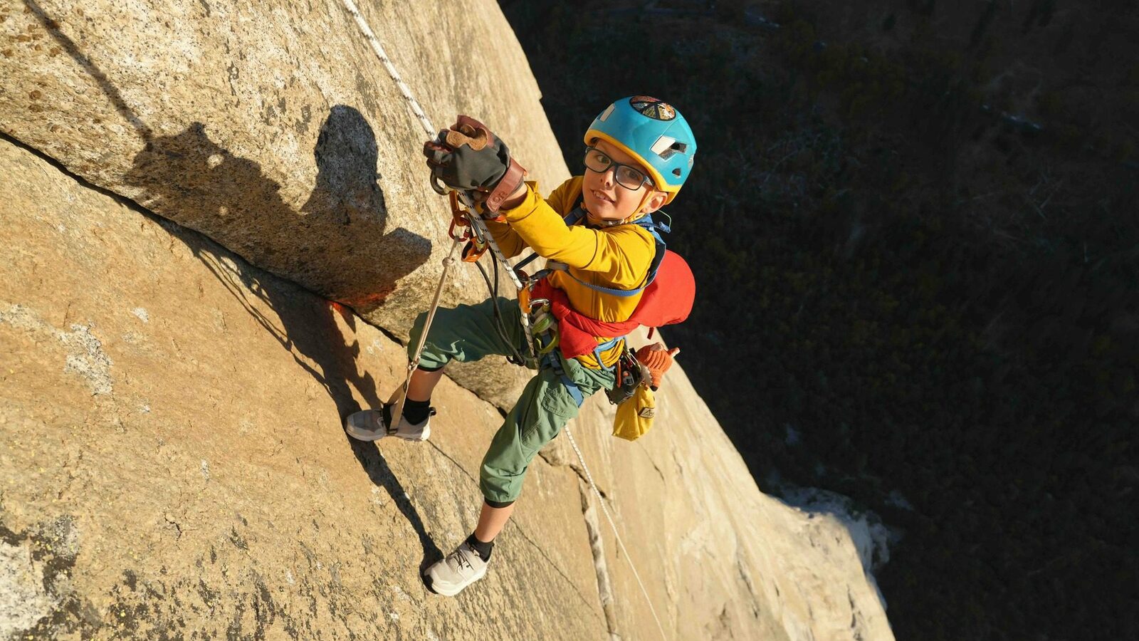 8yr old climber, Jackson Houlding, hangs from a rope as he jumars up the sheer rock face of El Capitan.