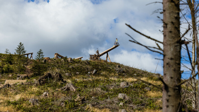 Gee Atherton and his Atherton Bike S200 poised on a wooden feature ready to take omn the windfell run 