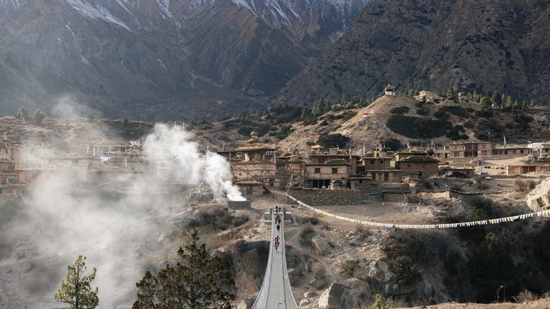 Kilian Bron and local childs on a suspension bridge in the remote Ringmo village, Dolpo, Nepal. 
