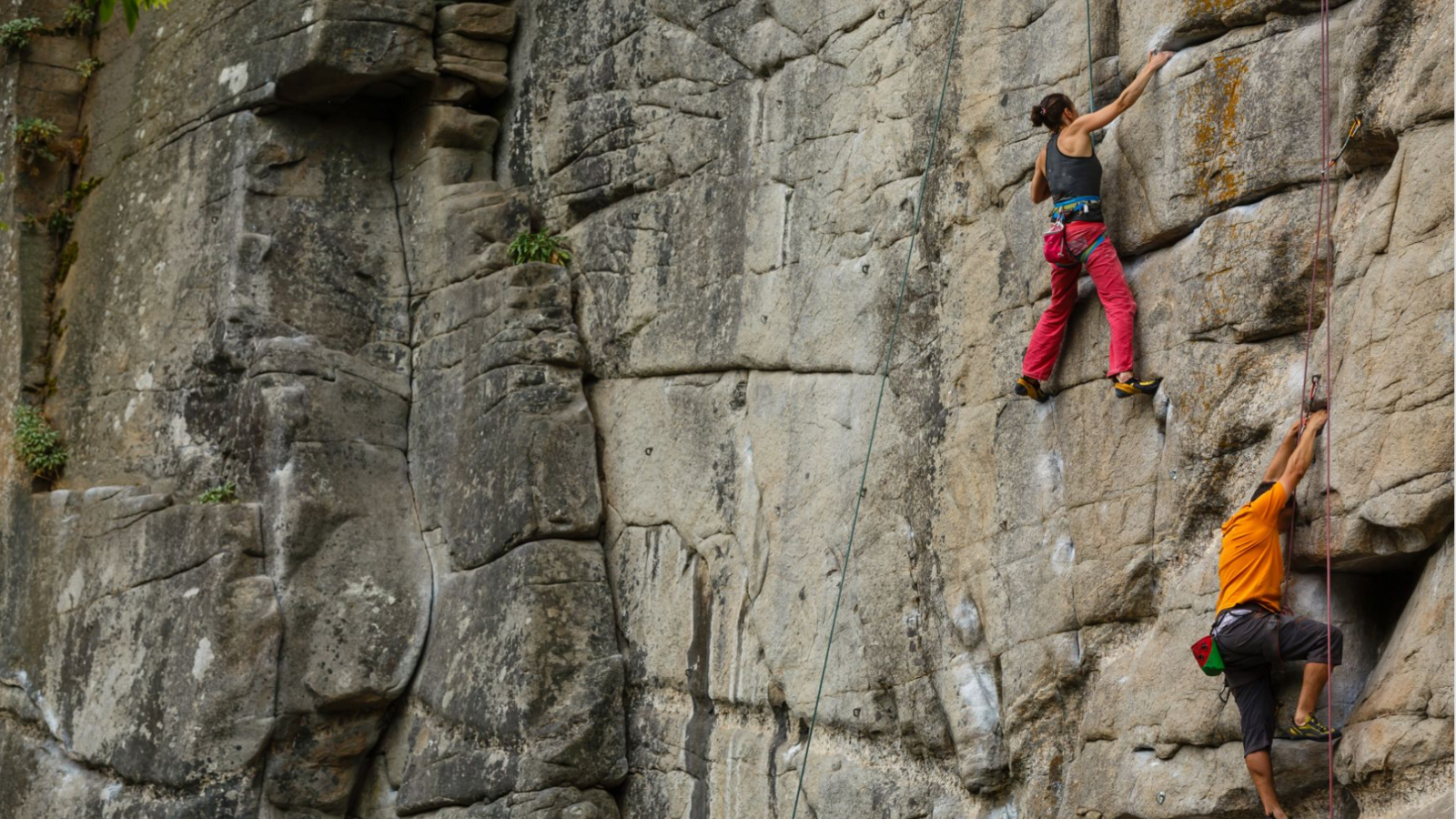 two rock climbers scale a gritstone cliff