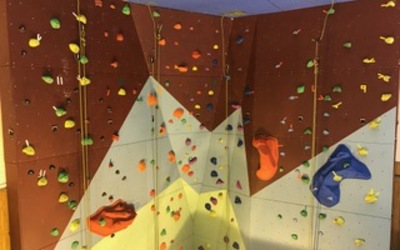 ropes hang down an empty indoor climbing wall