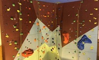 ropes hang down an empty indoor climbing wall