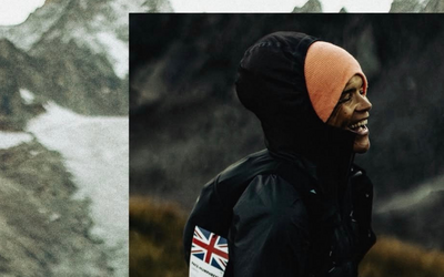 a person adorned in a black jacket and hood smiles